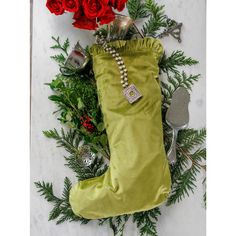 a christmas stocking with red roses and other holiday decorations on the floor next to it