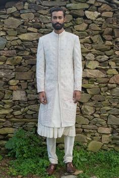 White sherwani with embroidery and sequin work. Comes with off white kurta, pants and juttis.
Components:4
Pattern:Embroidery
Type of Work:Thread Embroidery and Sequin
Neckline:Band
Sleeve Length:Full
Fabric:Bhagalpuri Silk and Cotton Silk
Color:White
Other Details:
Side slits
Gathered kurta
Closure: Hook front
Note: The off white sherwani set worn by the other model is not for sale
Note: The off white jacket sherwani set worn by the other model is not for sale
Occasion:Wedding - Aza Fashions White Thread Embroidery, Embroidered Sherwani, Off White Jacket, Kurta Set For Men, White Kurta, Cotton Embroidery, Thread Embroidery, Designer Gowns, Kurta Set