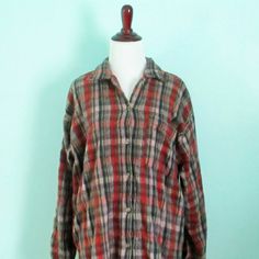 a red and black plaid shirt on a mannequin's dummy head stand