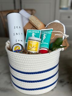 a white basket filled with lots of items on top of a marble counter next to a cup