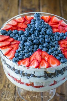 an american flag trifle with blueberries and strawberries in the center on a cake stand