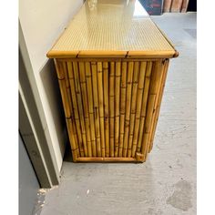 a table made out of bamboo sitting next to a wall