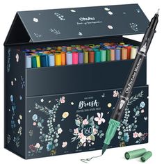 an assortment of crayons and markers in a black box with floral designs on it