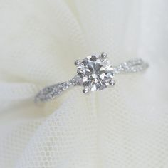 a diamond ring sitting on top of a white cloth