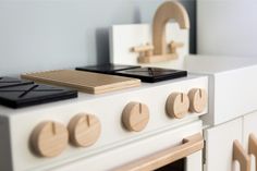 a close up of a stove top oven with wooden knobs on it's sides