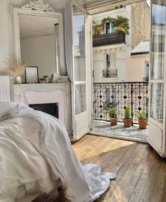 an open door leading to a balcony with a bed and mirror on it's side