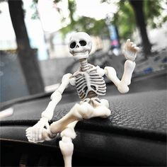 a toy skeleton sitting on top of a car dashboard