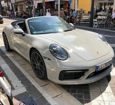 a white sports car is parked on the street