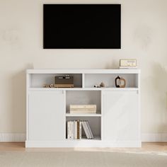 a white entertainment center with a flat screen tv mounted on it's side wall