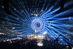 a large crowd at a concert with bright lights