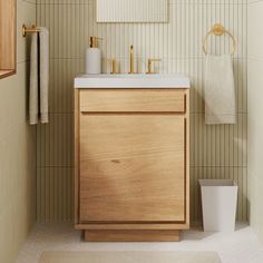 a bathroom with a sink, mirror and towel rack in it's corner next to a trash can