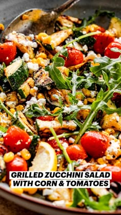 a salad with tomatoes, spinach, corn and feta cheese in a skillet