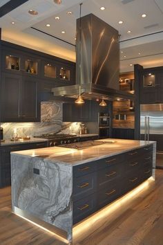 a large kitchen with marble counter tops and stainless steel appliances, along with wooden flooring