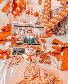 a laptop computer sitting on top of a bed covered in orange and white candies