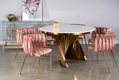 a dining room table with pink chairs around it