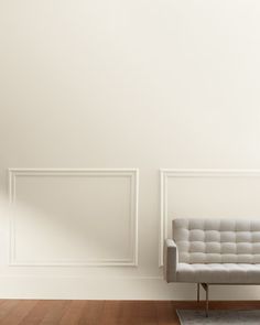 a white couch sitting in front of a wall