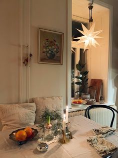 a dining room table with candles and fruit on it