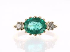 Featured here is a redefined emerald and diamond three-stone ring. This eccentric design showcases a natural 2.20-carat oval emerald set in a 14-prong setting. Accented are two brilliant round diamonds also set in a 5-prong setting on both sides. This unique ring was designed and custom-made by us! Setting: Three-Stone Metal Purity: 14K Yellow Gold Gold Weight: 3.6 Grams Main Stone: Emerald Shape: Oval Cut Weight: 2.20-Carats Clarity: Semi-Transparent Color: Medium Green Luster: Very Good Origin Luxury Oval Three Stone Emerald Ring, Luxury Oval Emerald Ring With Three Stones, Oval Emerald Three-stone Diamond Ring, Oval Three-stone Emerald Ring For Formal Occasions, Oval Emerald Three Stone Diamond Ring, Oval Three Stone Emerald Ring For Formal Occasions, Oval Emerald Diamond Ring With Three Stones, Heirloom Three Stone Emerald Diamond Ring, Heirloom Three Stone Emerald Ring