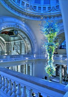 the interior of a building with blue lights and chandelier hanging from the ceiling