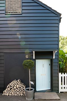 a black house with a blue door and white picket fence