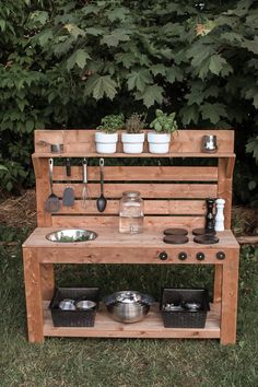 a potting bench with pots and pans on it in front of some trees