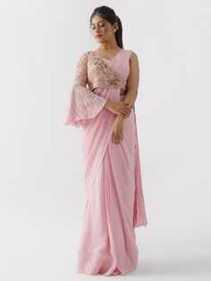 A three-piece blush pink saree set from the Suruchi Parakh collection. This beautiful pre drape saree is paired with a matching bustier. The outfit is completed with one shoulder jacket. The blush pink color touch enhances the graceful georgette crepe pre drape saree. The satin silk jacket has a bell-shaped sleeve along with handwork detail & floral print. Blush Pink Saree, Baby Pink Saree, Mirror Work Saree, Saree Jackets, Saree Designs Party Wear, Drape Saree, Floral Jacket, Indian Fashion Designers, Silk Jacket