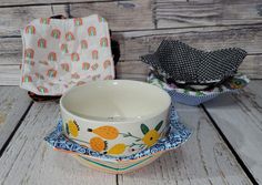 three bowls with different designs on them sitting next to each other in front of a wooden wall