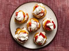 small pastries with strawberries and whipped cream on a plate