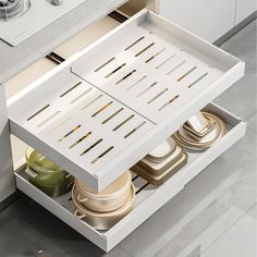 an open drawer in a kitchen filled with dishes