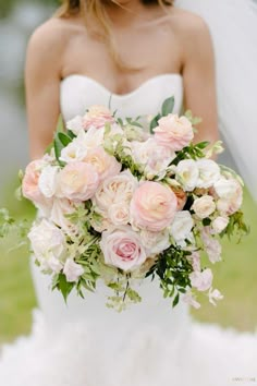 a bride holding a bouquet of pink and white flowers