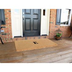 a front porch with a door mat on it