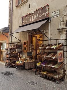 the outside of a store with baskets and bread on display