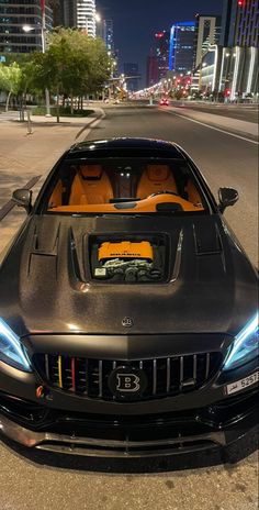 a black sports car parked on the side of the road in front of tall buildings