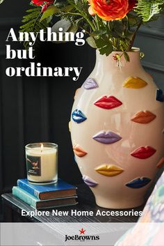 a vase with lipstick on it sitting next to a candle