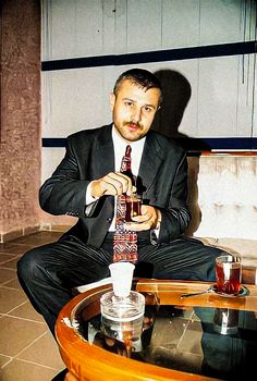 a man sitting at a table with a beer in his hand