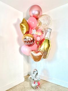 a balloon filled with champagne and balloons sitting on the floor in front of a wall