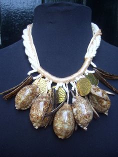 a close up of a necklace on a mannequin's neck with shells