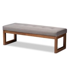 the bench is made from wood and has a light gray upholstered cushion on it