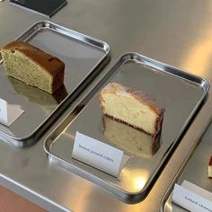 three trays with different types of cakes on them