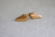 "Vintage 1980s gold tone metal Art Deco style earrings, with a clip back with an adjustable screw. Signed Piscitelli. Each measures 13/16\" tall x 1/2\" wide. In great condition, with very little wear; they have some very, very slight fading to the metal finish. ---> If you need an order shipped by a particular date or shipped via a quicker method, please ask PRIOR to purchase to see if we can accommodate that request. Visit the rest of our shop for more goodies ---> https://www.etsy.com/shop/Bl Gold Nugget, Gold Tone Metal, Art Deco Fashion, Clip On Earrings, Metal Art, Gold Metal, Gold Tones, Vintage Outfits, Etsy Earrings