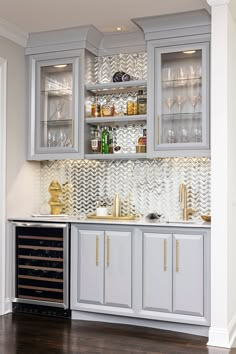 a kitchen with gray cabinets and gold trimmings on the glass front cabinet doors