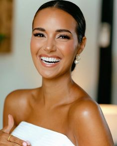 a woman in a white dress smiling and holding a napkin