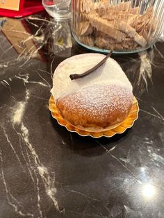 a pastry sitting on top of a table next to a glass bowl filled with food