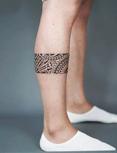 a person with a tattoo on their leg is standing up and wearing white socks,