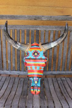 a cow skull sitting on top of a wooden bench