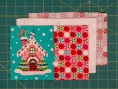 three pieces of fabric sitting on top of a cutting board next to a green cutting mat