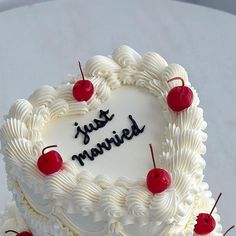 a heart - shaped cake with cherries and the words just married written on it