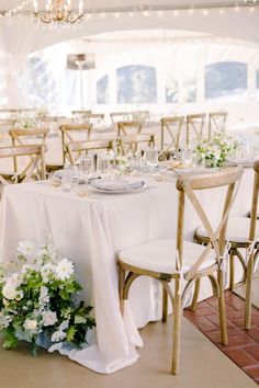 the tables are set up with white linens and gold chairs for an elegant wedding reception