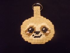 a cross stitch keychain with a skull on it