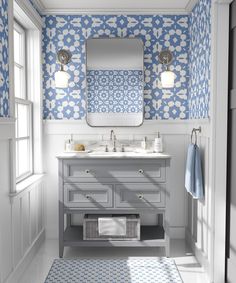 a bathroom with blue and white wallpaper on the walls, two sinks and a mirror